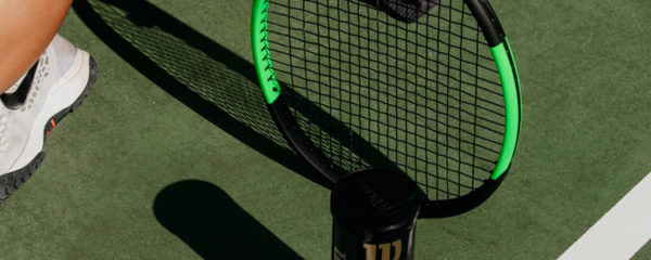 Raquettes et balles de tennis Wilson sur un court de tennis vert